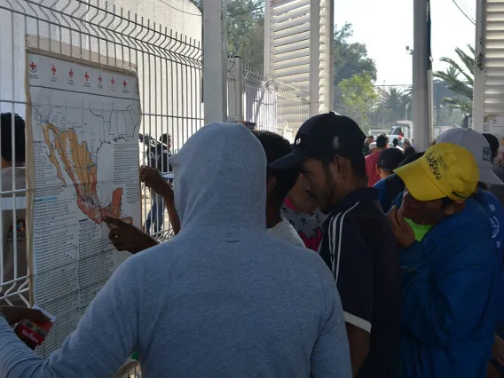 Migrants looking at maps of Mexico