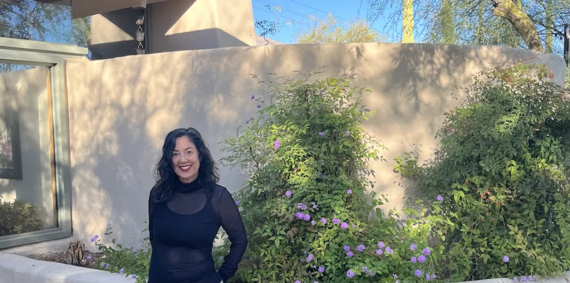 Stephanie Pearmain standing outside in front of flowers