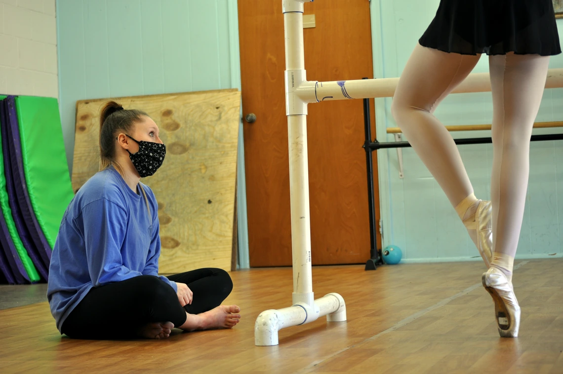 Sitting masked studenet watching dancer. Photo by Kate Ewing