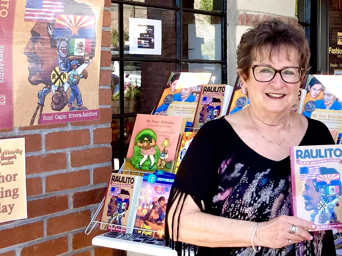 Roni Capin Rivera-Ashford with her book Raulito: The First Latino Governor of Arizona