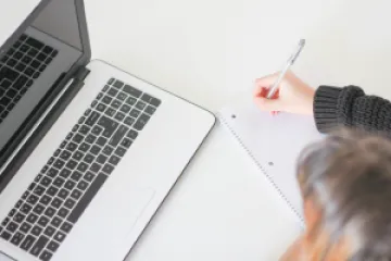 Person writing while on the phone