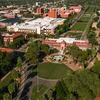 Aerial view of college campus with many red brick buildings and trees