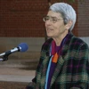 Woman stands at a podium, speaking