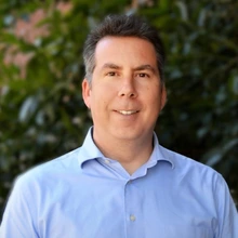 man with brown hair and wearing a blue shirt