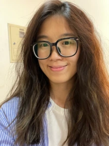 Woman with long brown hair and black framed glasses