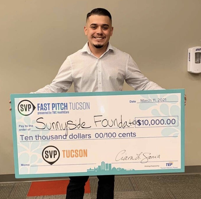 Patrick Robles holding large check from Fast PItch