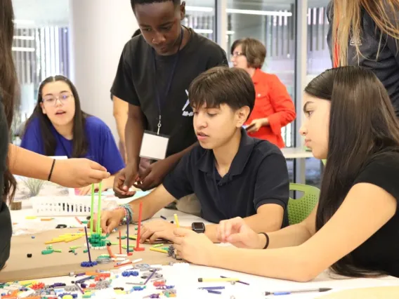 three middle school youths engaged in a building exercise