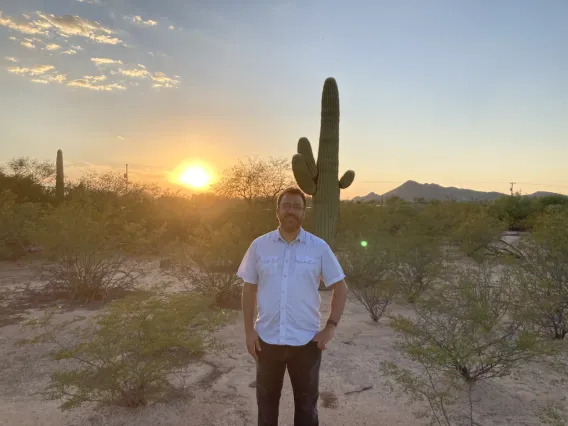 Estevan Azcona standing in front of a sunset