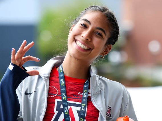 Female athlete showing Wildcat sign with right hand