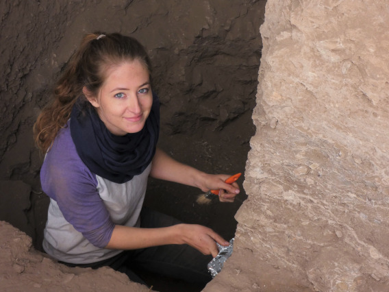 Kayla Worthey standing in a dig site, looking up.