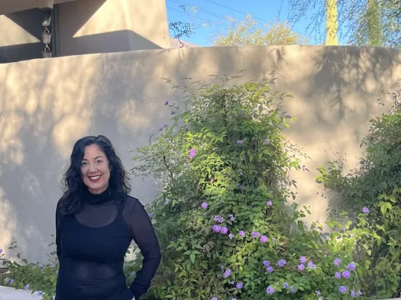 Stephanie Pearmain standing outside in front of flowers