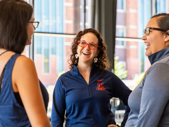 Three alumni talking in a group