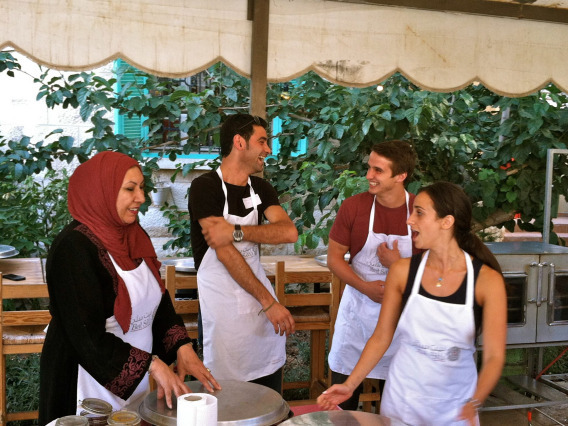 four young adults in the Middle East with aprons