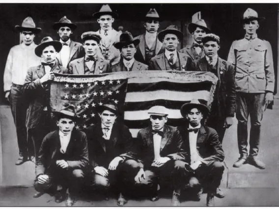 Black and white photo of 15 men during WWI timeframe, holding an American flag