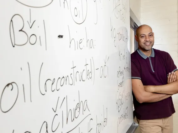 Corey Roberts against a white board with writing. 