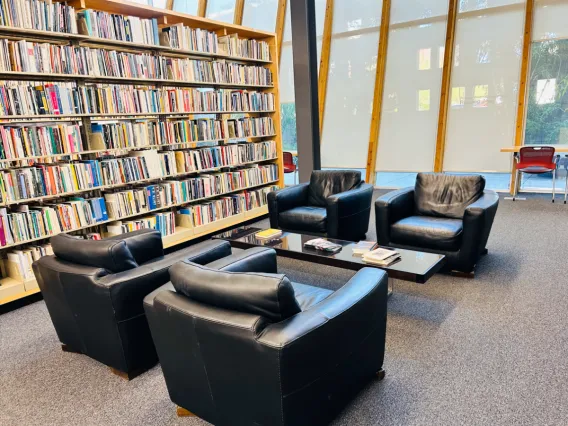 Photo of the Poetry Center showing a large bookshelf and four overstuffed chairs