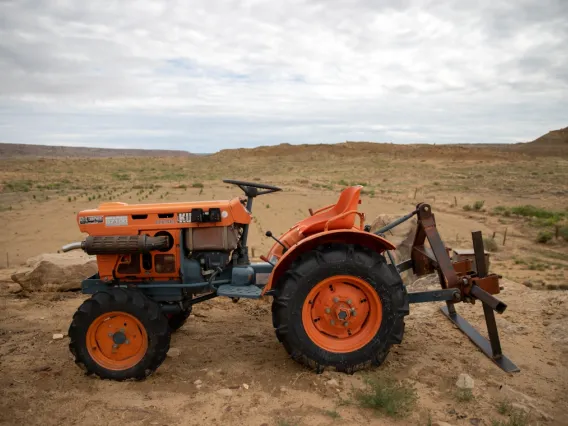 orange tractor on dirt lot