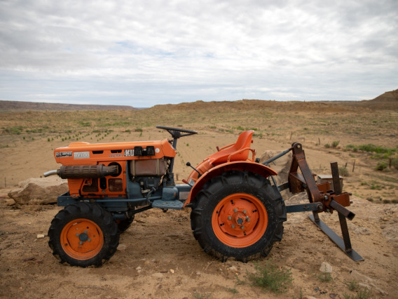 orange tractor on dirt lot