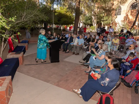 Mary Grier speaking in front of a group at the Womens Plaza of Honor