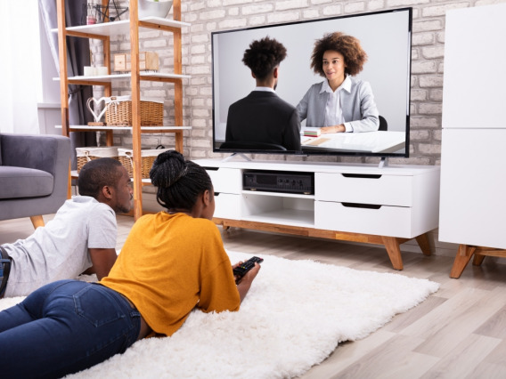 two Black young adults watching Black characters on TV