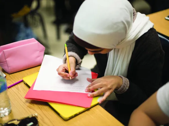 Female student writing in creative writing class