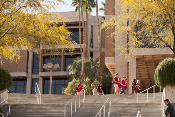 Main Library building on UArizona campus with students walking