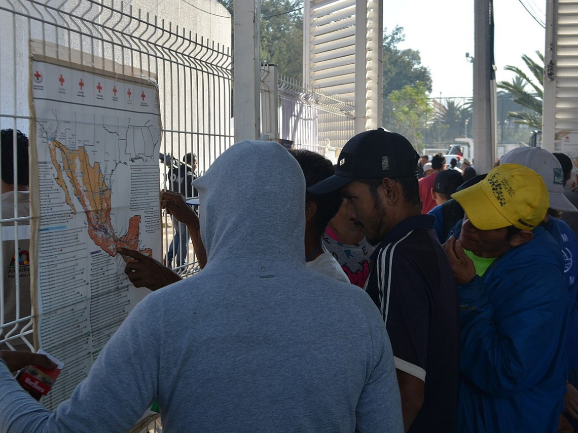 Migrants looking at maps of Mexico