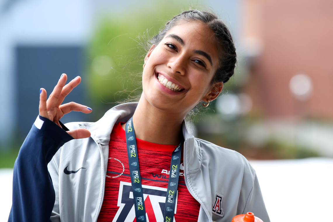 Female athlete showing Wildcat sign with right hand