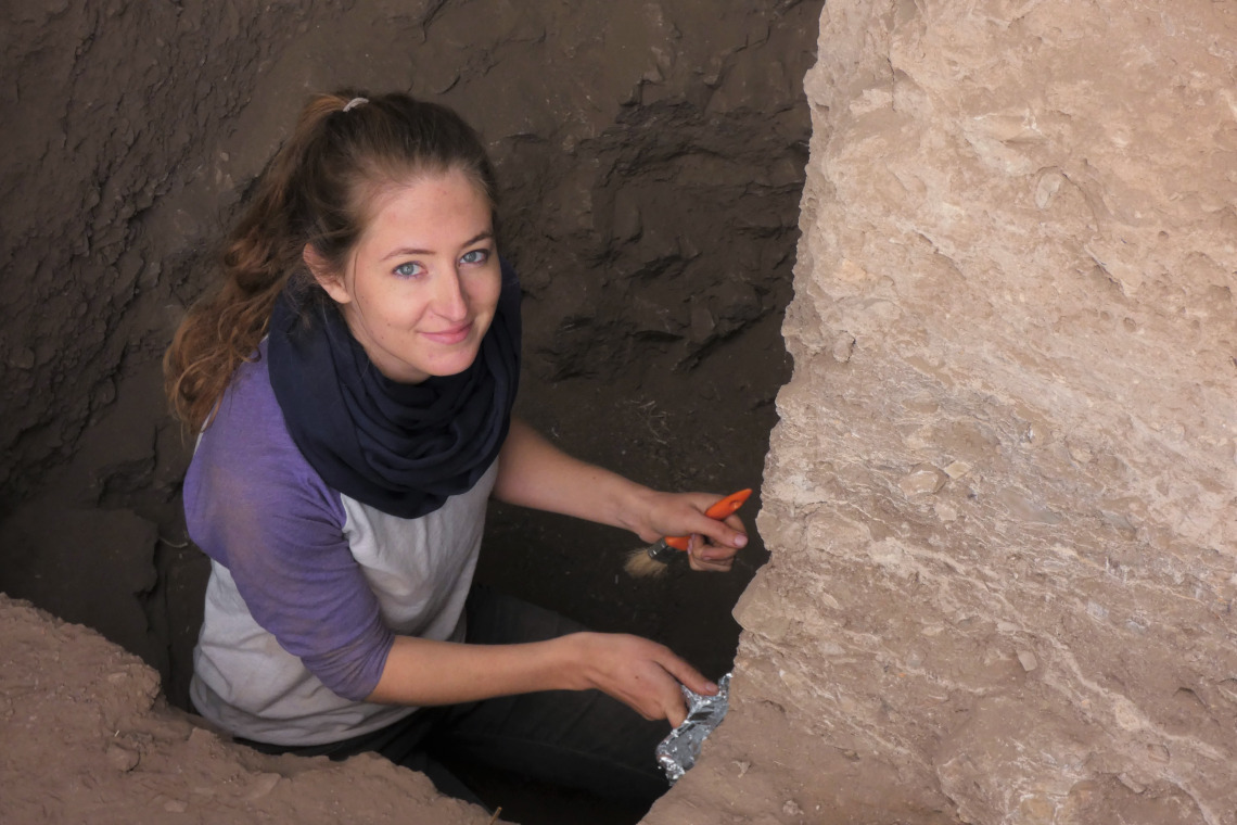 Kayla Worthey standing in a dig site, looking up.