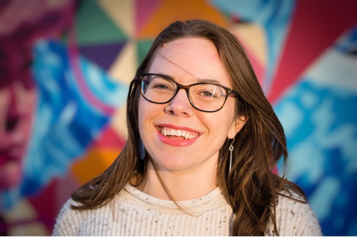 Melinda Englert smiles in front of a colorful background