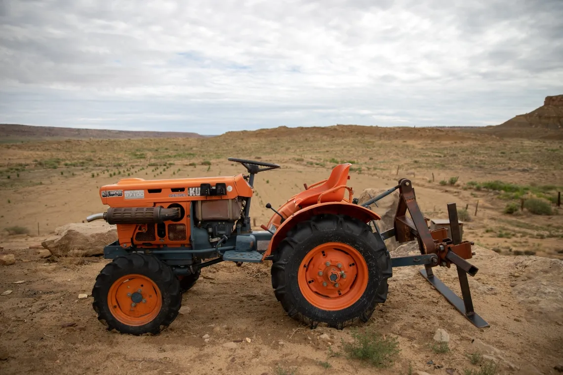 orange tractor on dirt lot