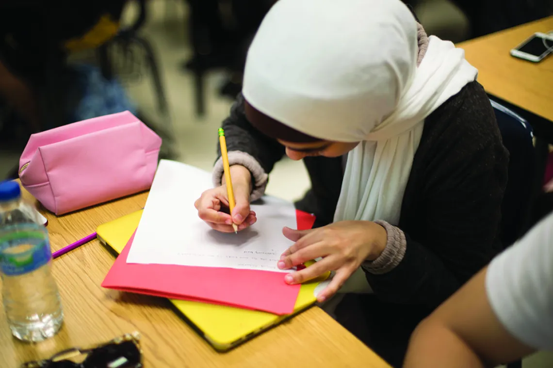 Female student writing in creative writing class