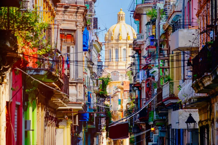 Colorful street in Old Havana with the Presidential Palace on the background