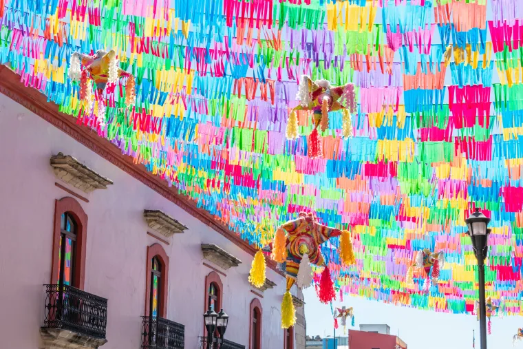 Street in Oaxaca decorated with colorful pinatas and flags, for december festivities