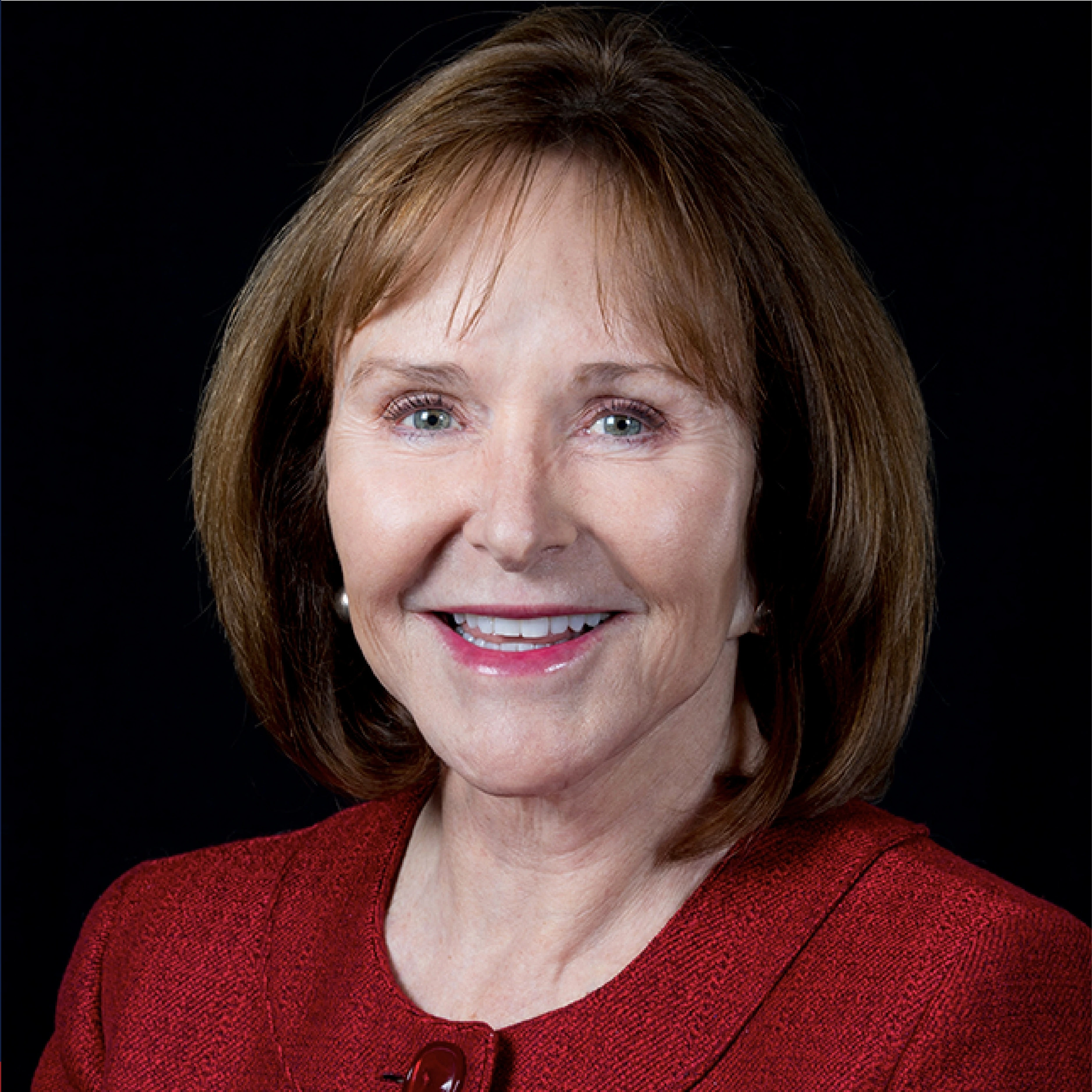 Jan Lesher smiles, wearing a red jacket
