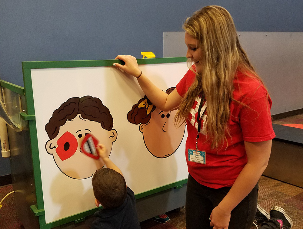 Linguistics student working with kids at Children's Museum