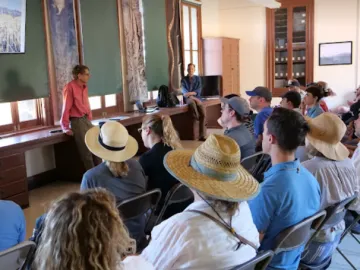 David Yetman presenting to group of people  in Desert Lab on Tumamoc Hill 