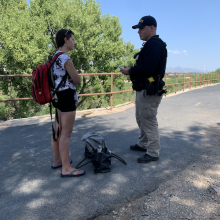 Police officer interaction with woman wearing a backpack