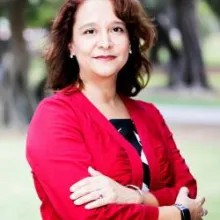 A woman with brown hair and wearing a red sweater