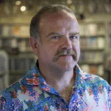 A man with a mustache and wearing a bright shirt