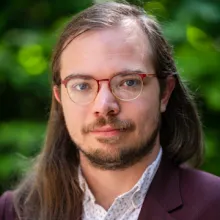 Man with a beard, long hair and glasses