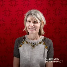 Woman with short blonde hair in front of a red background