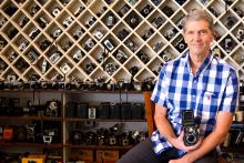 man posing with many cameras