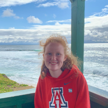 girl with ginger hair wearing a red UA sweatshirt