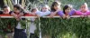 Seven school children stand behind a fence and look out onto a garden space